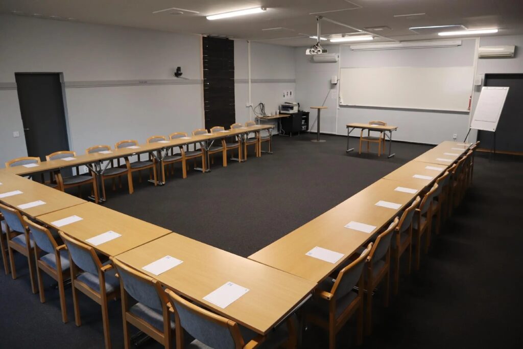 Konferensrum Esset på Höllviksnäs med u sittning, projektor och utsiktstavla över området Vy från höger