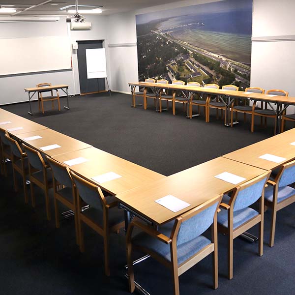 Konferensrum Esset på Höllviksnäs med u sittning, projektor och utsiktstavla över området