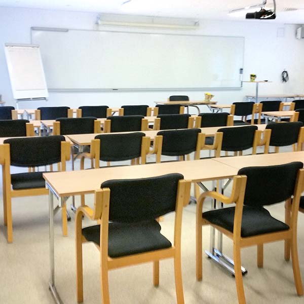 Konferensrum Knösen på Höllviksnäs med skolsittning, whiteboard och projektor för utbildning