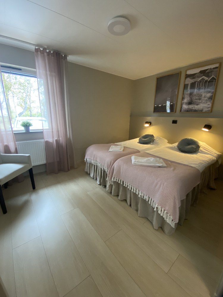 Ljust dubbelrum premium på Höllviksnäs med två bäddade sängar, sittplats och fönster