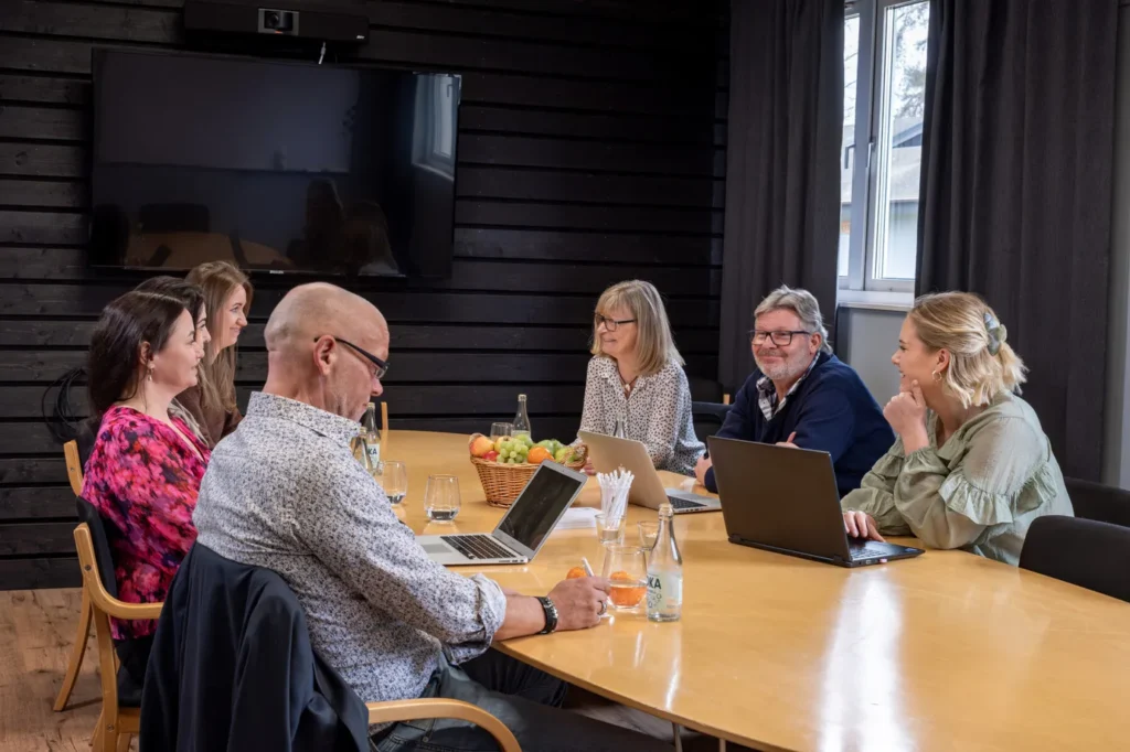 Möte på Höllviksnäs med konferensgäster runt bord i mindre mötesrum